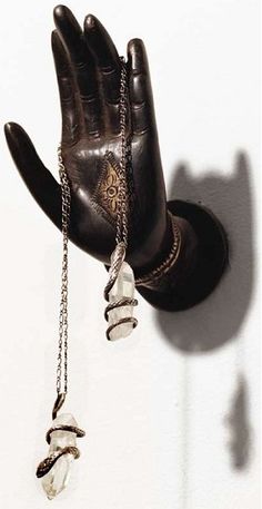 a pair of gloves hanging from a wall with chains attached to the back of it