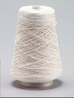 a spool of white yarn sitting on top of a table