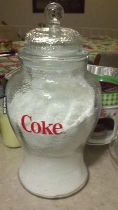 a glass jar filled with white sugar sitting on top of a counter