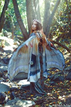 a woman is standing in the woods with her wings spread open and wearing a butterfly costume