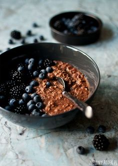 a bowl filled with blueberries and blackberries on top of a marble countertop