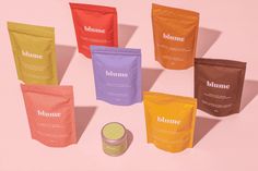 six bags of humme on a pink background