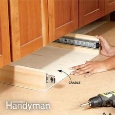 a woman laying on the floor with tools in front of her and an open drawer