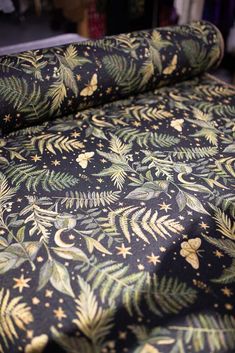 a black and gold patterned bed spread with stars, leaves and swirls on it