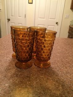 two gold colored glasses sitting on top of a counter