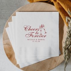 three napkins with the words cheers to forever printed on them sitting on a wooden platter