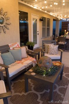 an outdoor living area with patio furniture and string lights