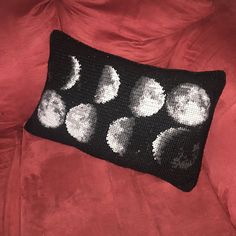 a black and white crocheted pillow with phases on it