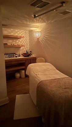 a spa room with a bed, sink and shelves on the wall next to it