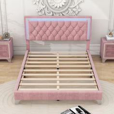 a bed with pink upholstered headboard and foot board in front of a mirror