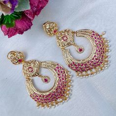 Long and oversized, yet comfortable to wear (55 GMs) Chandbali earrings made in sterling silver with 22K gold plating. It has been set with synthetic rubies and precious freshwater pearls. These statement earrings bring together timeless materials and intricate craftsmanship, offering a unique and sophisticated look that turns heads and stands out from the crowd. Elegant Chandbali Temple Jewelry Earrings, Chandbali Temple Jewelry Earrings With Elegant Design, Elegant Ruby Chandbalis With Meenakari, Gold Chandbali Bridal Earrings With Ruby, Gold Ruby Chandbali Bridal Earrings, Gold Fusion Style Chandbalis With Pearl Drop, Fusion Style Gold Chandbalis With Pearl Drop, Gold Fusion Chandbalis With Pearl Drop, Elegant Festive Hallmarked Chandbalis