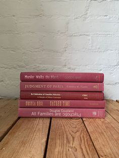 a stack of five books sitting on top of a wooden table