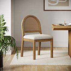 a chair sitting in front of a table with a potted plant next to it