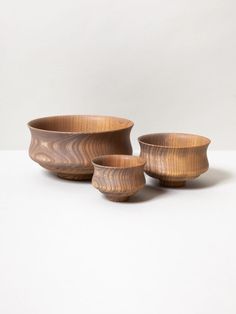 three wooden bowls sitting next to each other