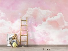 a ladder leaning against a wall in front of a pink and white cloud filled background