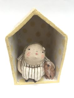 a ceramic figurine with a small animal in it's mouth, sitting inside an open hexagonal structure