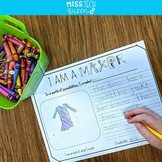 a child's hand holding a pencil next to a paper with writing on it