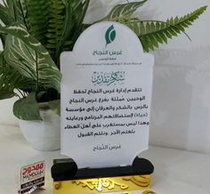 an award plaque sitting on top of a table next to a potted green plant