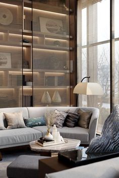 a living room filled with lots of furniture and large windows covered in shades of light