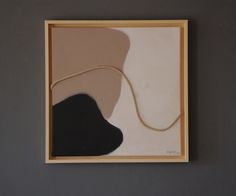 an abstract painting with black and white shapes on a gray background in a wooden frame