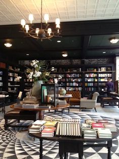 a room with tables, chairs and bookshelves full of books on the shelves