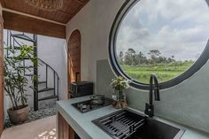 a kitchen with a large round window on the wall and a sink in front of it