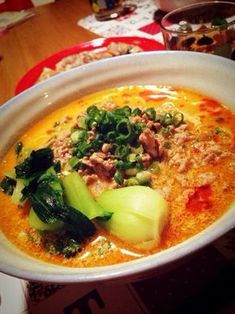 a white bowl filled with soup and vegetables