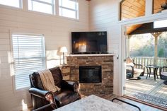 a living room filled with furniture and a flat screen tv on top of a fireplace