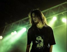 a man with long hair standing on stage