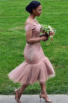 a woman in a pink dress is walking down the street with her bouquet and shoes on