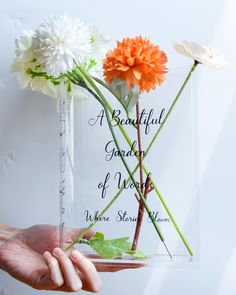 a person holding a vase with flowers in it that reads, a beautiful garden of words