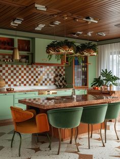 an image of a kitchen setting with green and brown colors on the counter top, chairs around the island