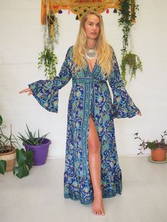 FLEETWOOD WRAP DRESS - RUBY SPARROW - TANGLED UP IN BLUE Our Signature wrap dress is back! This blue ditsy print is soft & has a floral & ethereal feel to it. The colours are soft & complimenting & the print is effortlessly beautiful. For a limited time only & with limited prints available, our Stevie Nicks inspired wrap around kimono dress is BACK! With the most beautiful billowing sleeves, buttery soft fabric and flowing frills these are some of our favourite bespoke creations ever! The tie ca Blue Long Sleeve Maxi Dress With Ruffles, Hippie Blue V-neck Dress, Vintage Blue Maxi Dress For Vacation, Green Bohemian Dress With Bell Sleeves, Green Bohemian Bell Sleeve Dresses, Blue Fitted Dress With Bell Sleeves, Fitted Blue Dress With Bell Sleeves, Vintage Summer Dress With Kimono Sleeves, Blue Vintage Long Sleeve Dress