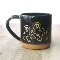 a black and brown coffee mug with two skulls on it