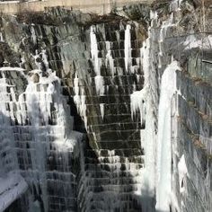 the water is frozen and flowing over the rocks