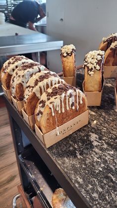 several different types of pastries sitting on top of a counter in a bakery setting