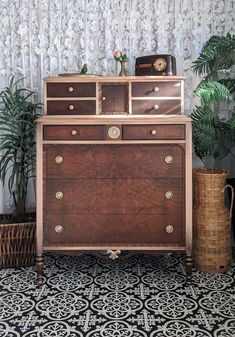 an old dresser with some plants in front of it