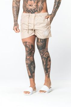 a man with tattoos on his body wearing shorts