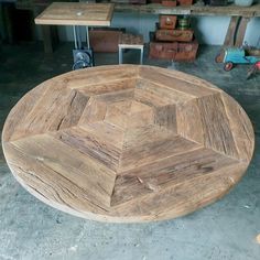 a wooden table sitting in the middle of a room next to other tables and chairs