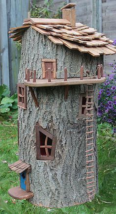 a tree house with ladders on the roof and windows built into it's side