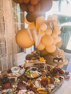 a table topped with lots of food and balloons