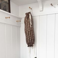 a cat laying on the floor next to a coat rack