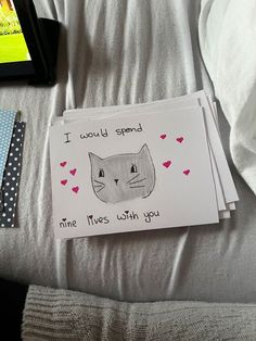 a card with a cat drawn on it next to a cell phone and other items