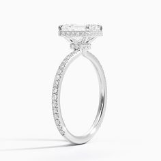 a white gold ring with diamonds on the sides and an oval shaped diamond in the center