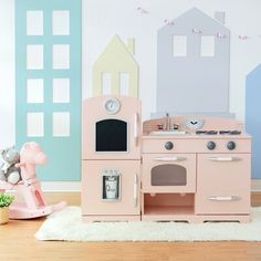 a toy kitchen set with pink and blue walls in a child's playroom