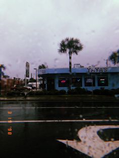 an intersection with palm trees in the rain