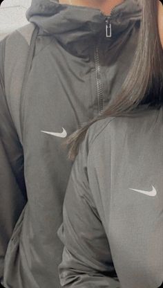 the back of a woman's hoodie with nike logo on her left side