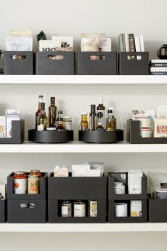 the shelves are filled with different types of bottles and other items in black bins