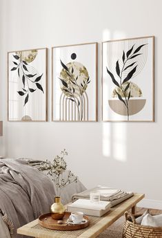 three framed art prints hanging on the wall above a bed in a room with neutral colors