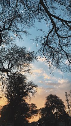 the sun is setting behind some trees